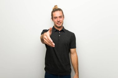 İyi bir anlaşma kapanış için el sıkışan beyaz duvarın üzerinden uzun saçlı sarışın adam