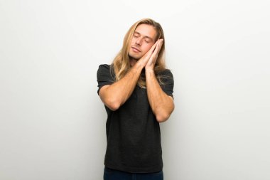 Beyaz duvar yapım uyku hareketle dorable ifade üzerinde uzun saçlı sarışın adam