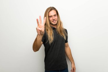 Beyaz duvar mutlu ve sayım üç parmaklı üzerinde uzun saçlı sarışın adam