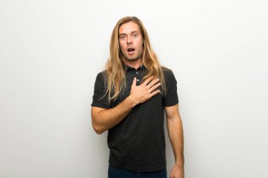 Şaşırttı ve doğru bakarken şok beyaz duvarın üzerinden uzun saçlı sarışın adam