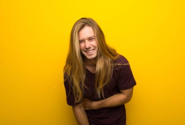 Gülümseyen süre geçti silah tutmak sarı duvarın üzerinden uzun saçlı sarışın adam