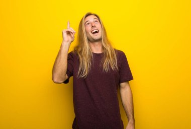 Parmak kaldırma sırasında çözüm sarı duvar niyetinde üzerinde uzun saçlı sarışın adam anlar