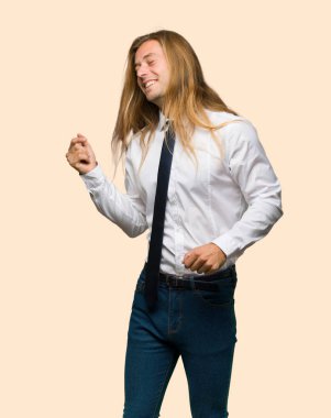 Uzun saçlı sarışın işadamı zevk müzik izole arka plan üzerinde bir partide dans