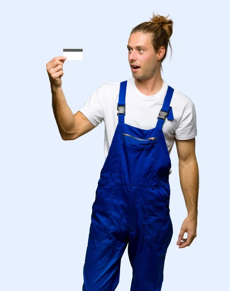 Workman Holding Van Een Credit Card Verrast Geïsoleerde Achtergrond — Stockfoto