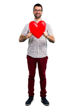 Gözlüklü bir kalp simgesi tutan yakışıklı adam