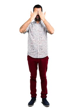 Gözleri eller tarafından kapsayan gözlüklü yakışıklı adam