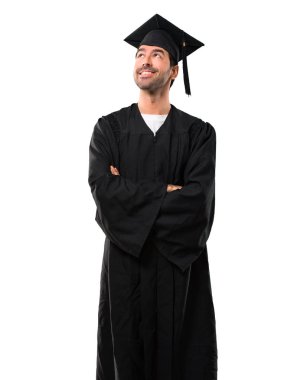 Adam onun mezuniyet günü Üniversitesi stand ve izole beyaz arka plan üzerinde gülümseyen ararken