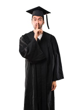 Adam onun mezuniyet günü Üniversitesi ağız ve sessizlik kapanış bir işaret gösteren izole beyaz zemin üzerine ağzına koyarak parmak jest