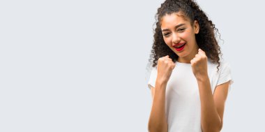 Young girl with curly hair annoyed angry in furious gesture. Frustrated by a bad situation on grey background