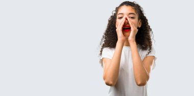 Geniş açık ağız ile bağırarak ve gri arka plan üzerine bir şey ilan kıvırcık saçlı Genç kız