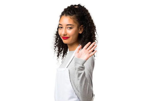 Молодая Девушка Фартуке Салютует Рукой Счастливым Выражением Белом Фоне — стоковое фото