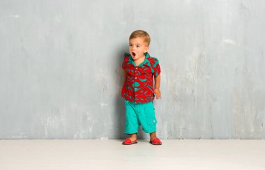 Vintage grunge arka plan üzerinde mutlu küçük bebek sürpriz jest yapma