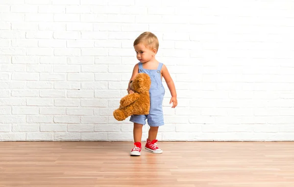 Adorable Bebé Con Peluche Sobre Fondo Ladrillo Blanco —  Fotos de Stock