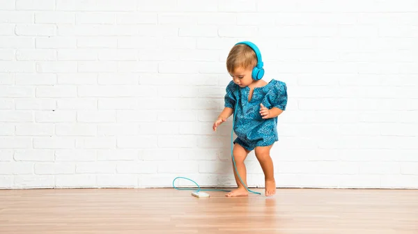 Adorable Bebé Escuchando Música Sobre Fondo Ladrillo Blanco —  Fotos de Stock