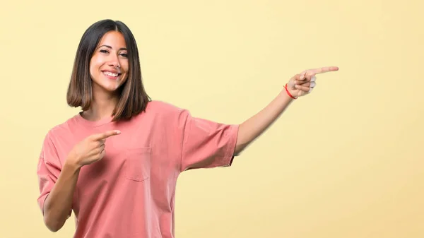 Młoda Dziewczyna Różową Koszulę Wskazując Palcem Bok Prezentacji Produktu Jednocześnie — Zdjęcie stockowe