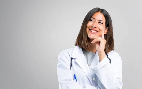 Médica Mulher Com Estetoscópio Pensando Uma Ideia Sobre Fundo Cinza — Fotografia de Stock