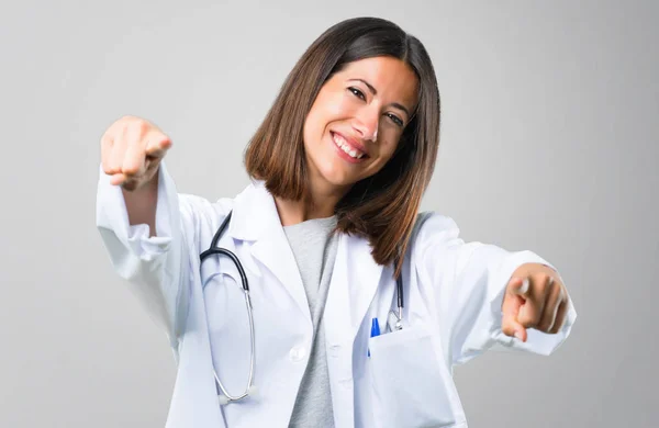 Dokter Vrouw Met Stethoscoop Punten Vinger Terwijl Glimlachend Grijze Achtergrond — Stockfoto