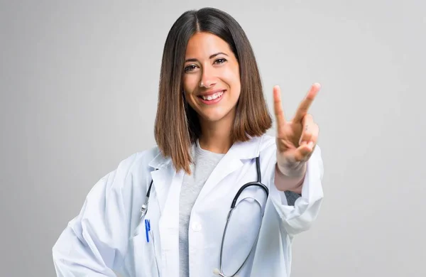 Γιατρός Γυναίκα Στηθοσκόπιο Χαμογελώντας Και Δείχνοντας Σύμβολο Της Νίκης Γκρίζο — Φωτογραφία Αρχείου