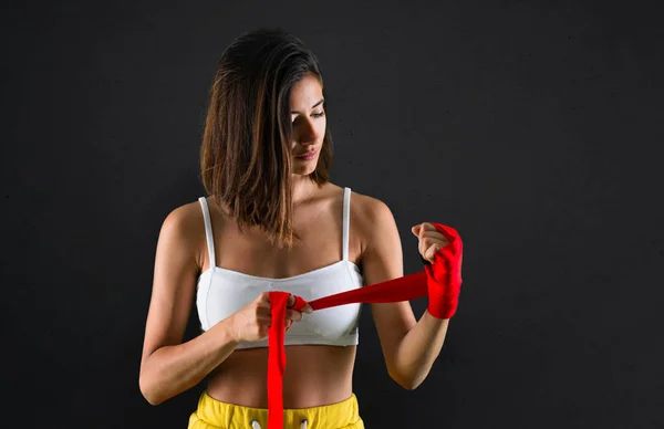 Sport woman with boxing bandages on black background