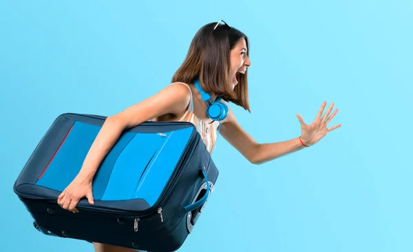 Ragazza Che Viaggia Con Sua Valigia Correndo Veloce Sfondo Blu — Foto Stock