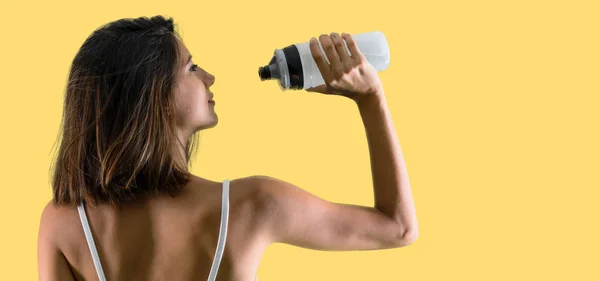 Mujer Deportiva Con Una Botella Sobre Fondo Amarillo —  Fotos de Stock