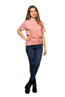 A full-length shot of a Teenager girl with pink sweater posing with arms at hip and laughing on isolated white background