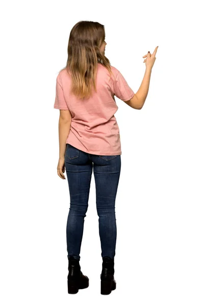 孤立した白い背景に真剣な顔で見上げるピンクのセーターを持つティーンエイジャーの女の子のフルレングスショット — ストック写真