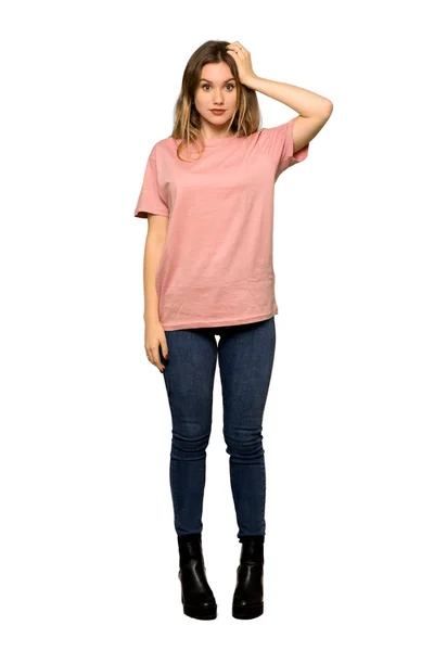 欲求不満の表情と孤立した白い背景に理解していないピンクのセーターを持つティーンエイジャーの女の子のフルレングスショット — ストック写真