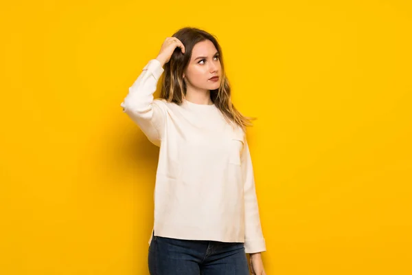 Nastolatek Dziewczyna Nad Żółte Ściany Mając Wątpliwości Podczas Drapania Głowy — Zdjęcie stockowe