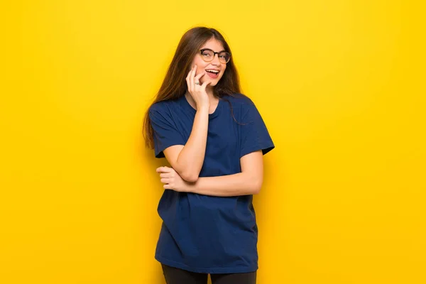 Mujer Joven Con Gafas Sobre Pared Amarilla Sonriendo Con Una — Foto de Stock