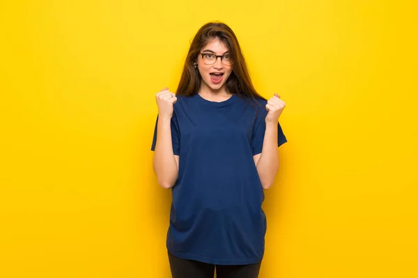 Mujer Joven Con Gafas Sobre Pared Amarilla Celebrando Una Victoria — Foto de Stock