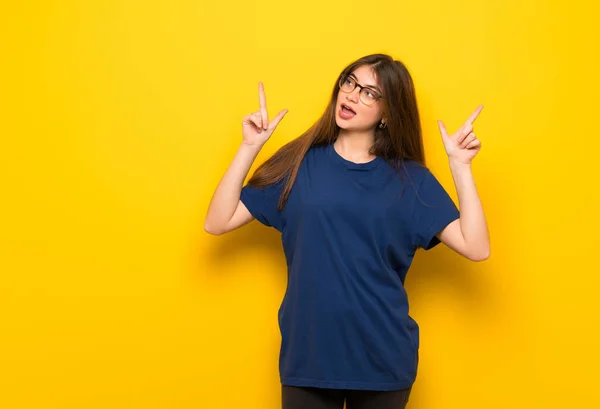 Jonge Vrouw Met Bril Gele Muur Wijzen Met Wijsvinger Een — Stockfoto