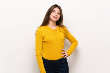 Silah, kalça ile poz ve gülümseyen sarı kazaklı genç kadın