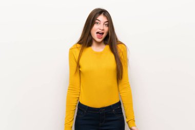 Young woman with yellow sweater shouting to the front with mouth wide open