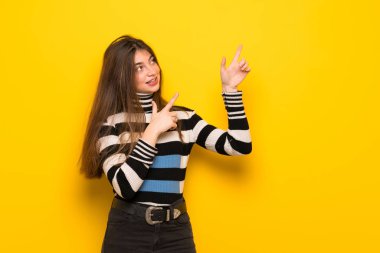 Genç kadın parmağı ile işaret ve ararken sarı duvarın üzerinden