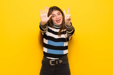 Yedi parmak ile sayma sarı duvarın üzerinden genç kadın