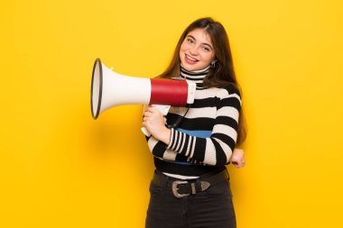 Sarı duvar bir megafon tutan genç kadın