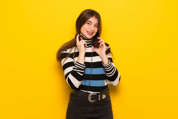 Junge Frau Mit Kopfhörern Über Gelbe Wand — Stockfoto