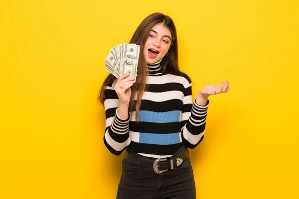 Joven Mujer Sobre Pared Amarilla Tomando Montón Dinero —  Fotos de Stock