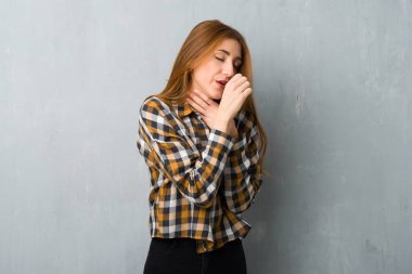 Genç Kızıl saçlı kız grunge duvarın üzerinden öksürük ile acı ve kötü hissediyor