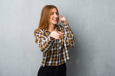 Genç Kızıl saçlı kız telefon jest yapma ve açık işaret grunge duvarın üzerinden