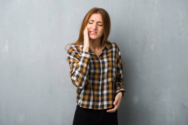 Grunge duvar diş ağrısı ile genç Kızıl saçlı kız