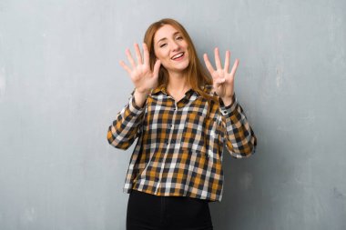 Dokuz parmaklı sayma grunge duvarın üzerinden genç Kızıl saçlı kız