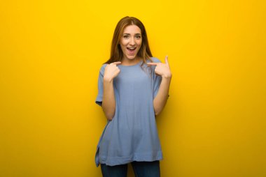 Sarı duvar arka plan sürpriz yüz ifadesi ile genç Kızıl saçlı kız