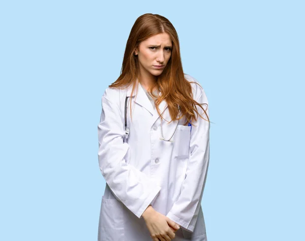 Rossa Medico Donna Con Espressione Triste Depressa Sfondo Blu Isolato — Foto Stock