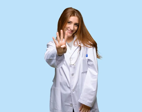 Ruiva Médico Mulher Feliz Contando Quatro Com Dedos Fundo Azul — Fotografia de Stock