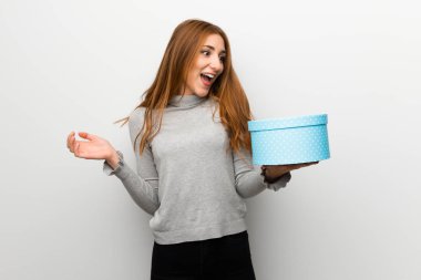 Beyaz duvar hediye kutusu elinde tutan Kızıl saçlı kız