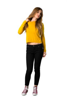 Genç bir kız ile yorgun ve hasta ifade izole beyaz zemin üzerine sarı kazaklı tam uzunlukta bir kadeh