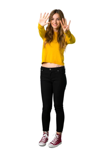 一个年轻女孩的全长照片 她穿着黄色毛衣 在孤立的白色背景上用手指数着九块 — 图库照片