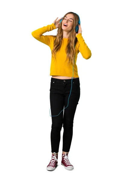 Полнометражный Снимок Молодой Девушки Жёлтом Свитере Слушающей Музыку Наушниках Изолированном — стоковое фото